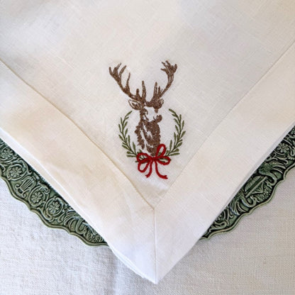 Embroidered linen napkin with a deer design on a white background
