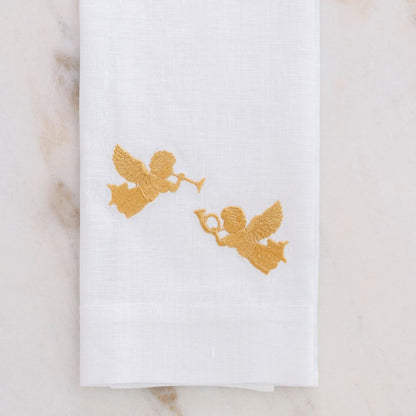 White linen towel with gold angel designs on a marble surface