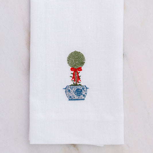 White towel with embroidered topiary design on a marble surface