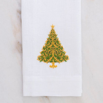 White linen towel with a decorative green and gold Christmas tree design on a marble surface.