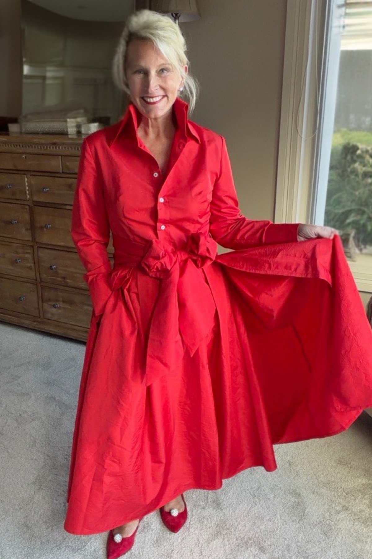 Woman wearing a Peggy Dress with the Red Taffeta Sash Overskirt holding out the side of the overskirt