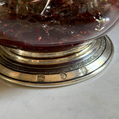 Close-up of the handcrafted pewter base of the Arte Italica Tavola Covered Bowl, showing Italian artisan hallmark stamps, filled with berry preserves