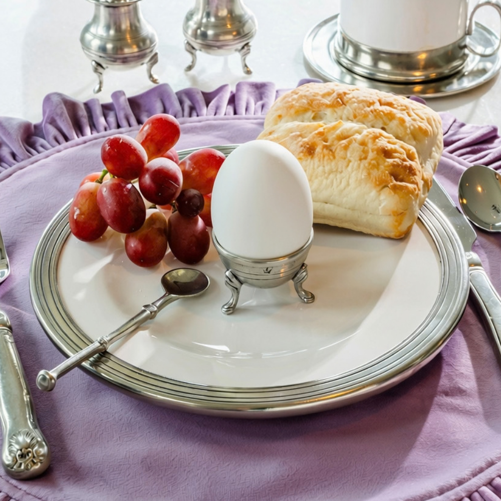 Table set with a lavendar placemat, Tuscan salad plate with a Tavola pewter egg cup with grapes and toast