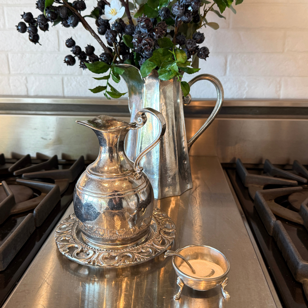 Tavola salt cellar with spoon sitting on a stove with an oil bottle and pitcher