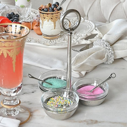 Decorative table with colorful sprinkles in small bowls in Tavola condiment server on a marble surface