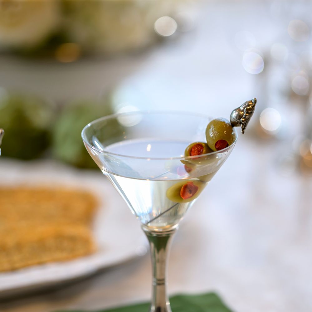 Martini glass with olives on a Pewter Pear Pick with blurred background
