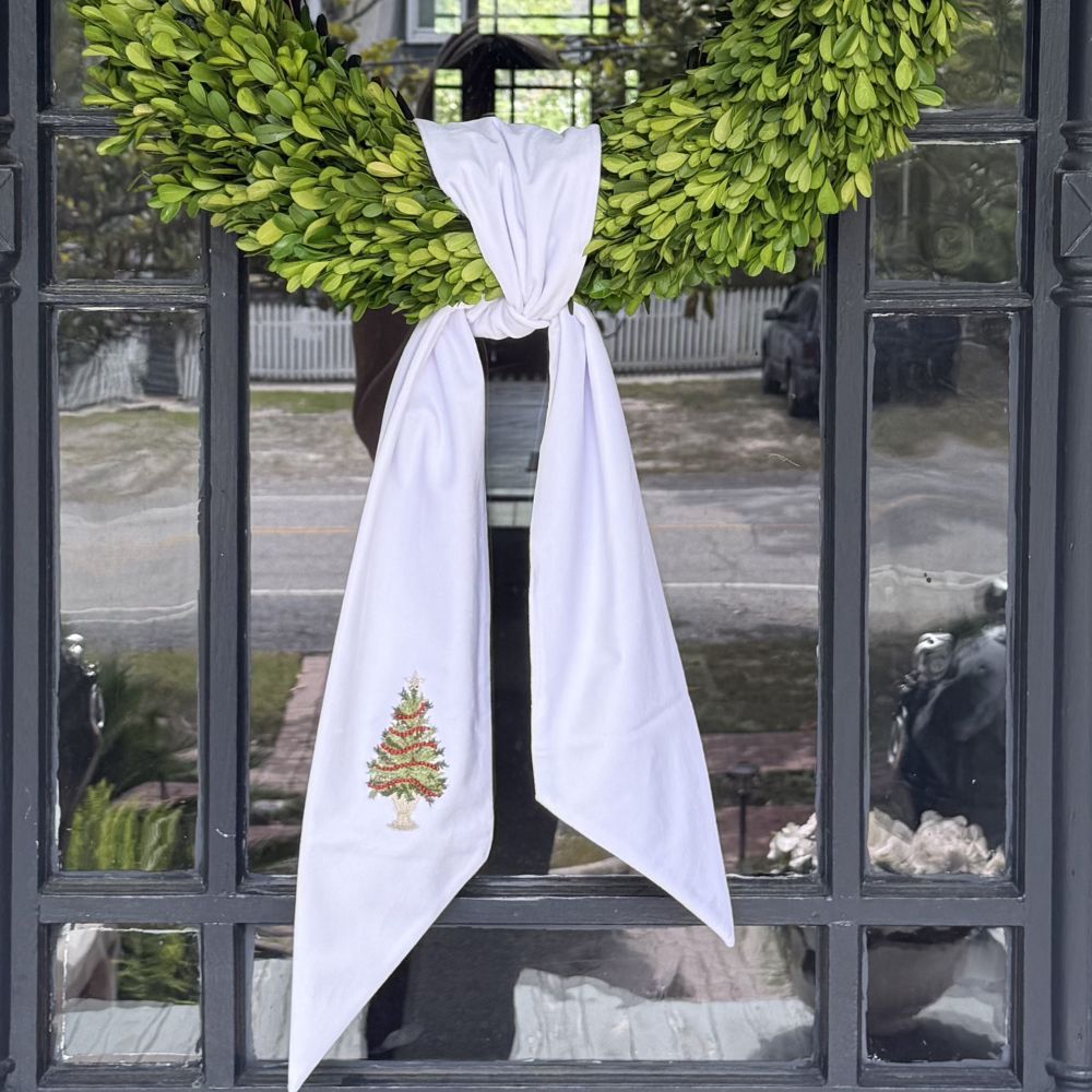 Decorative wreath with a White Velvet Tree with Trim Bow on a black metal door by Crown Linen Designs