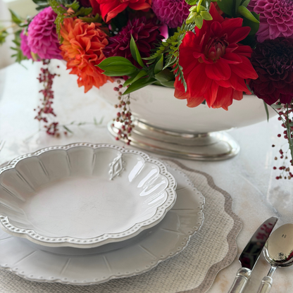Tuscan footed bowl with bright arranged flowers in it with Bella Bianca Soup Bowl and Splendido Placemat