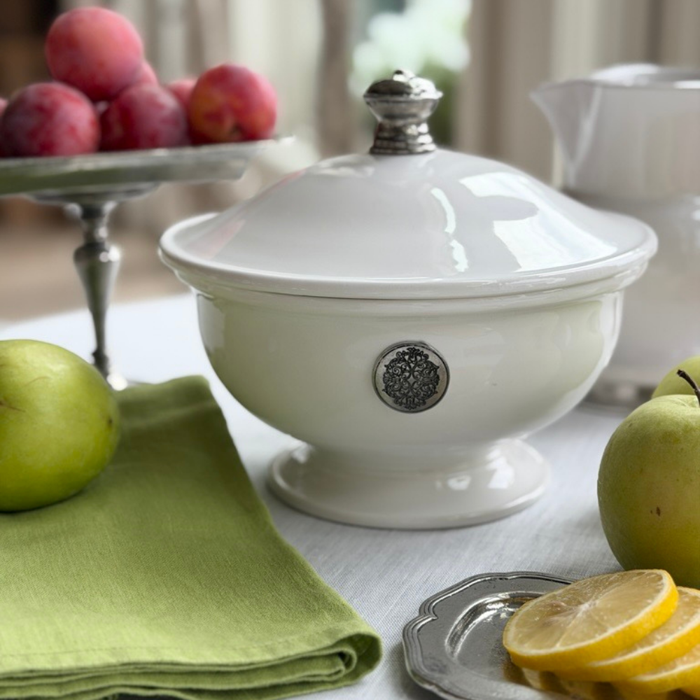 Tuscan small lidded ceramic round tureen with pewter decorative tab on a table