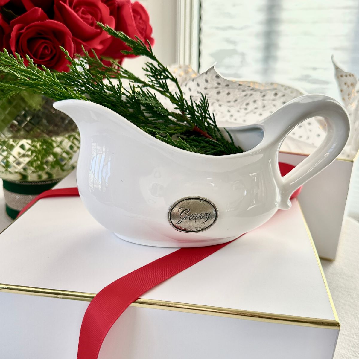 Tuscan Pewter Tab Gravy Boat on a white gift box with greenery and roses in the background