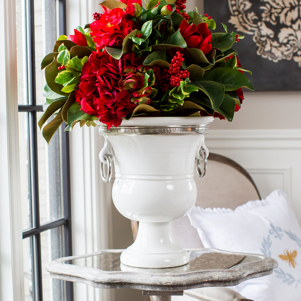 Tuscan Ceramic Signature Urn with Red Flowers on a side table