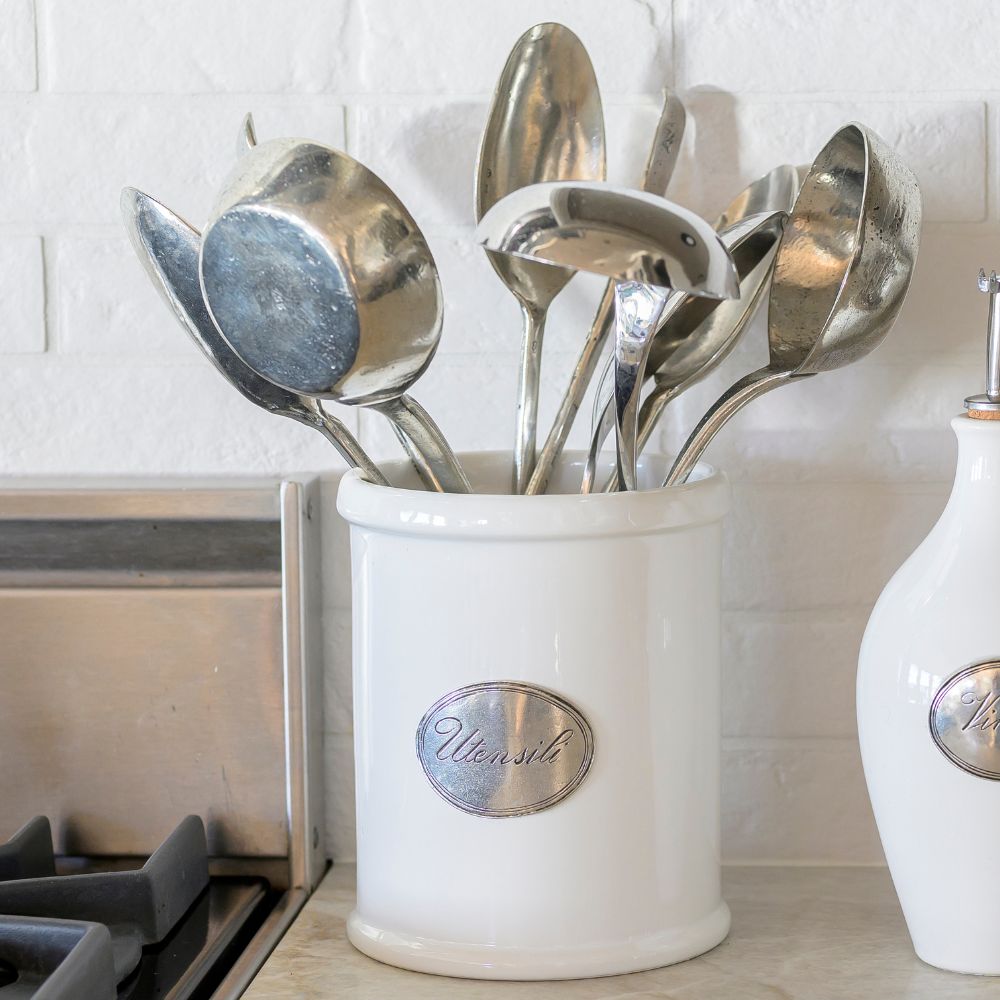 Tuscan ceramic white container with 'Utensil' label on a kitchen counter holding utensils