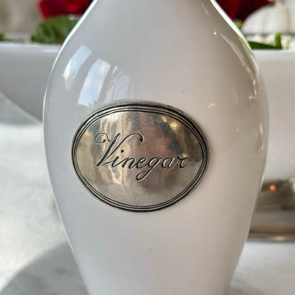 Close up of oval pewter tab on Tuscan white Vinegar Bottle