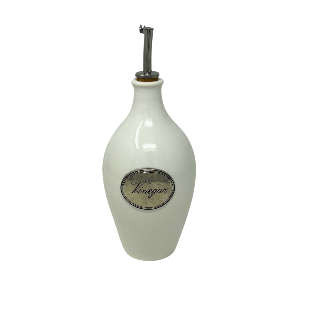 A white ceramic Tuscan vinegar bottle with a  spout top and a pewter round label that reads 'Vinegar'.