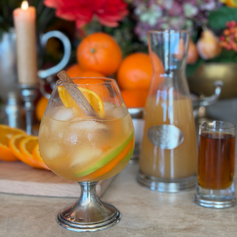 Side view of Arte Italica Verona Cognac Glass showing wide bowl and Italian pewter stem filled with apple cider cocktail
