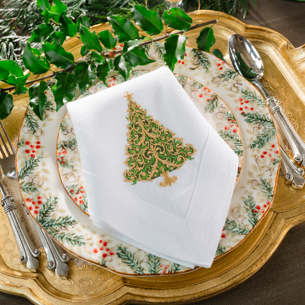 Natale plates on a Florentino Gold tray with a Versailles Christmas Tree White Large Linen Napkin folded on top with a green holly sprig