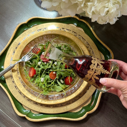 Place setting of Vetro Gold with a salad on a table and a person pouring dressing from a Vetro gold small decanter