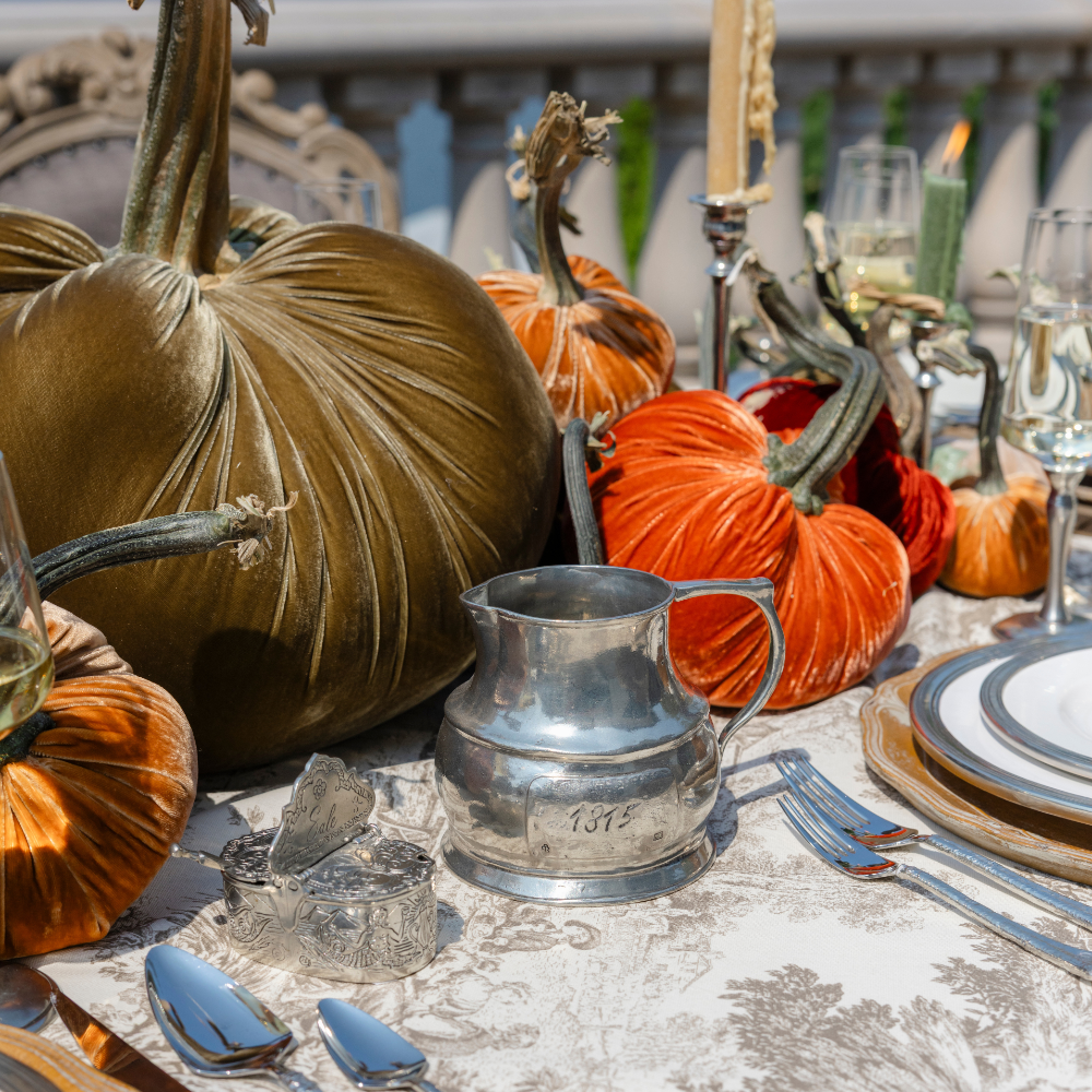 A pewter Vintage 1815 large pitcher on a fall table with velvet pumpkins on a Montefalco Latte Toile tablecloth
