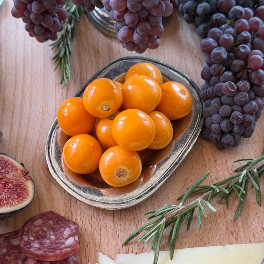 Close up of the Vintage bedside tray being used on a charcuterie board with Gooseberries on it and grapes and rosemary around it