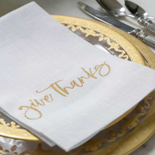Give Thanks Tri-Fold Napkin in gold embroidered letters on gold rimmed plate