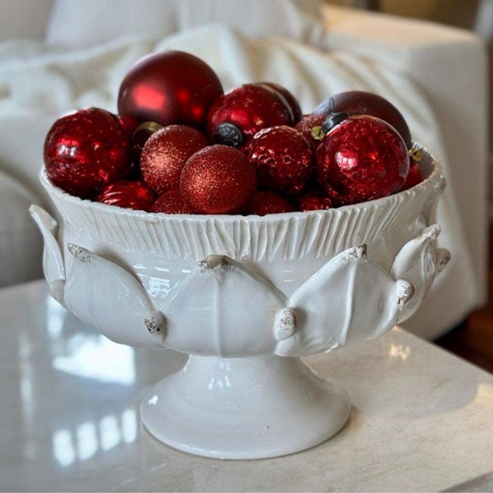Scavo Harvest White decorative bowl filled with red ornaments on a marble surface