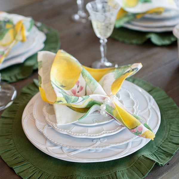 Arte Italica Bella Bianca ribbon charger Italian stoneware with plate stack and italian lemon napkin and green linen placemat