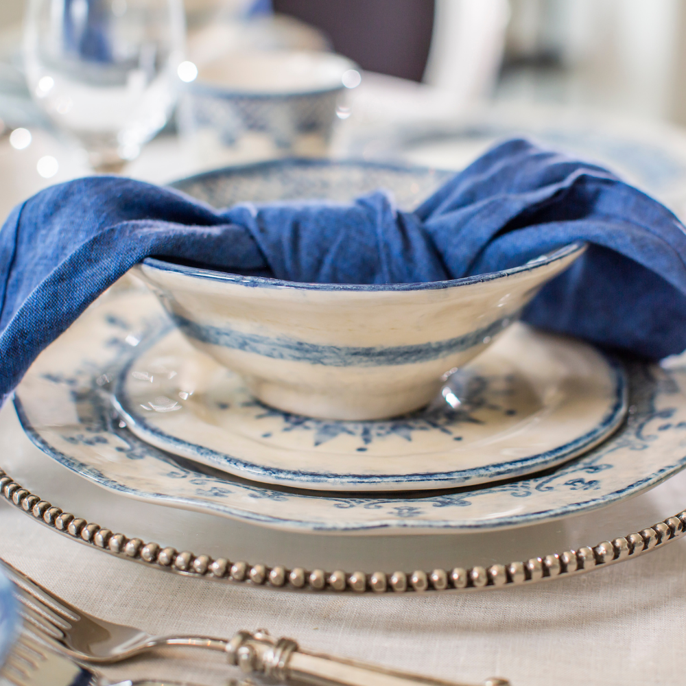 Arte Italica Burano cereal bowl blue ceramic Italian hand painted dinnerware, ceramic breakfast bowl side view with napkin on plates