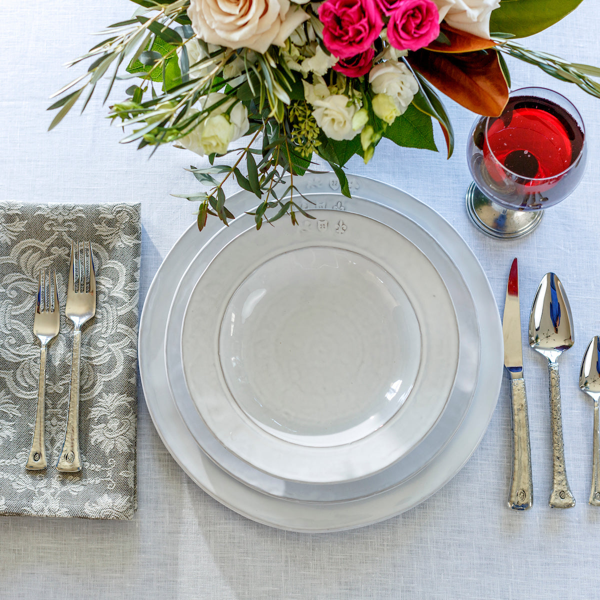 White Firenze Stoneware Pasta Bowl and Dishes on a white linen tablecloth with Verona Wine Glass