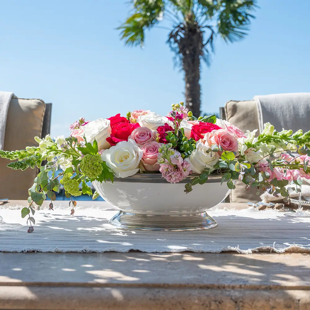 Large Tuscan footed bowl with handles in bianco white ceramic and pewter accents, shown with flowers as a vase.