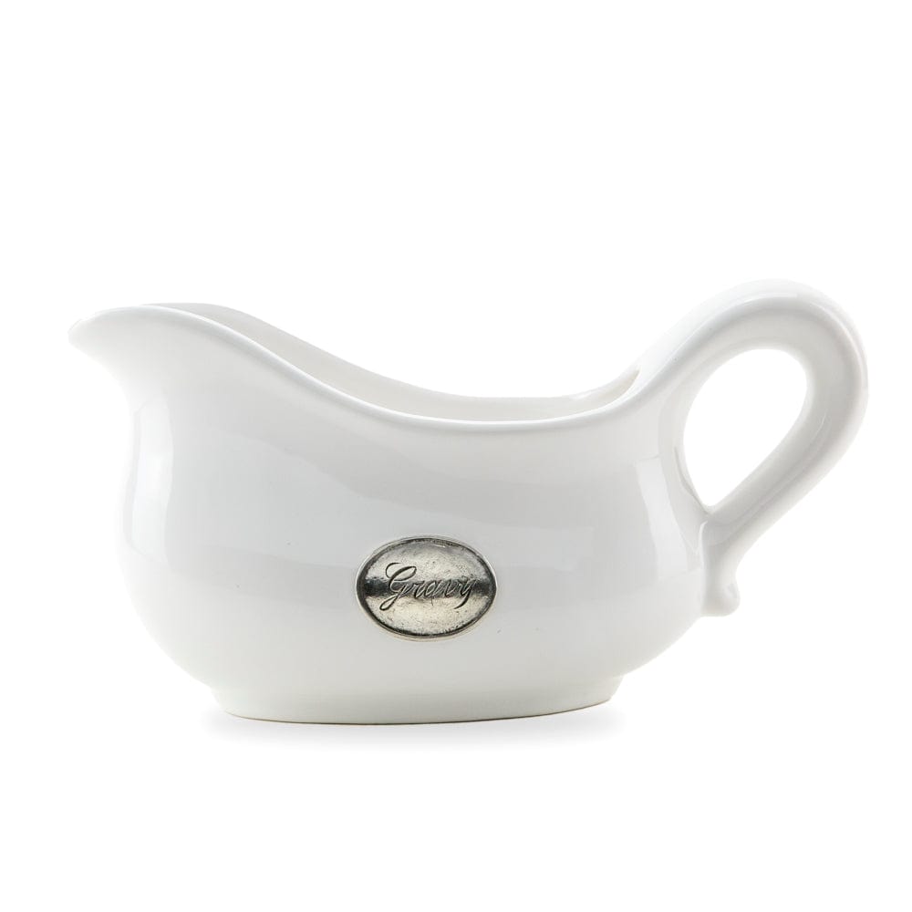 A white ceramic gravy boat with hand-rubbed pewter detailing and a gravy tab on the front, against a plain background.