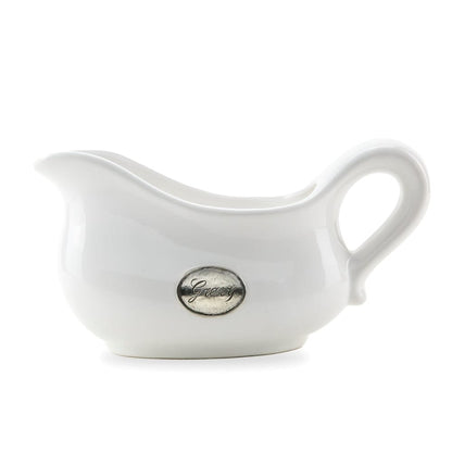 A white ceramic gravy boat with hand-rubbed pewter detailing and a gravy tab on the front, against a plain background.
